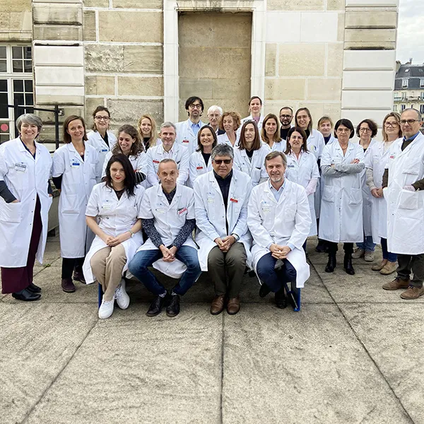 Photo de groupe de professionnels de santé en blouse blanche sur les marches d’un bâtiment historique