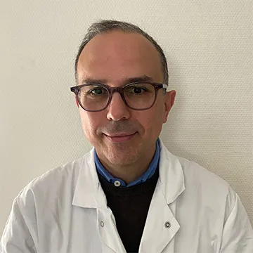 Portrait du Professeur Mikael Mazighi, expert en neurologie et neuroradiologie interventionnelle, vêtu d’une blouse blanche.